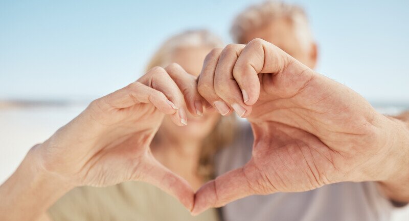 Image of a pair of couple make a heart shape with their hands